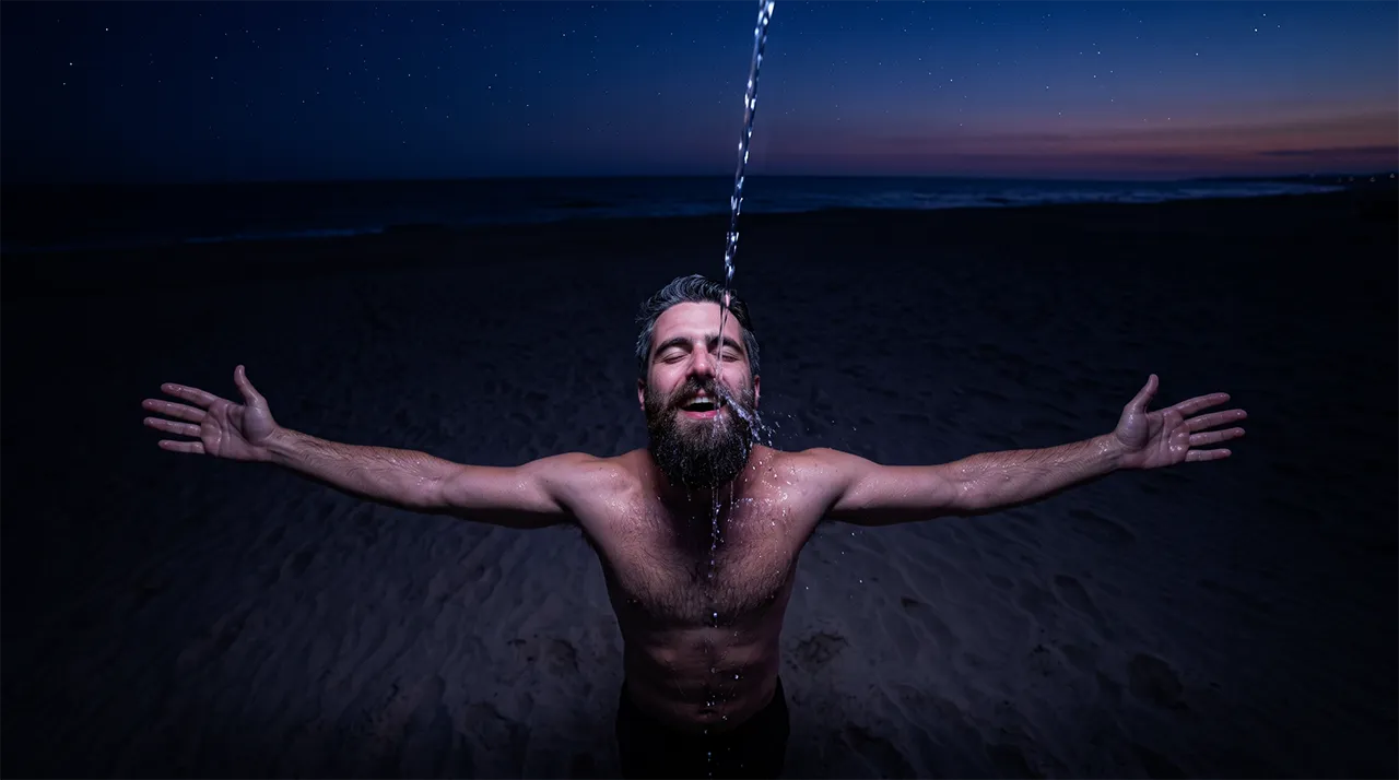 Un squirt sobre la cara de un hombre en la playa